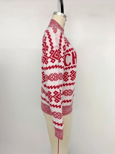 Detailed close-up of red and white knit sweater showing geometric patterns and woven letters