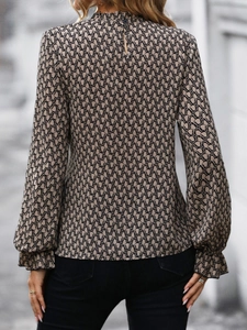 Detail view of women's long sleeve shirt featuring geometric prints and back button closure