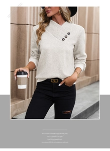 Detail of off-white knit sweater showing diamond texture and side marble buttons