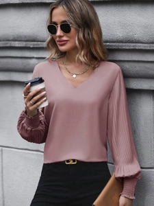 Detail of elegant V-neck blouse with pleated lantern sleeves in a dusty rose pink shade