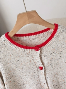 Chunky knit cardigan in beige fleck yarn with red ribbed collar and heart-shaped buttons