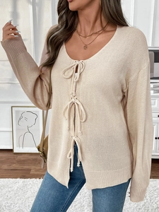 Detailansicht der hellbeigen Strickjacke mit zarten Schleifen und gerippter Textur-Details