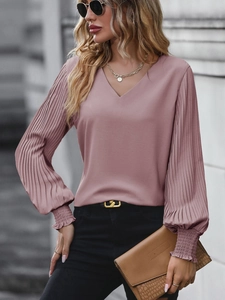 Detail showing the pleated lantern sleeves and ruffled cuffs of the mauve V-neck shirt