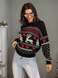 Detail of Christmas reindeer and heart jacquard pattern on a black knit sweater