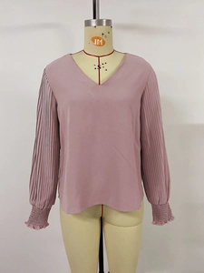 Detail view of pink pleated lantern sleeves and elastic ruffled cuffs on a women V-neck top