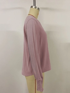 Detail of pleated puff sleeves with elastic cuffs on mauve minimalist casual blouse