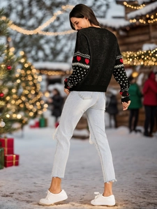 Detail of red heart jacquard and white polka dots on black knitted Christmas sweater sleeves