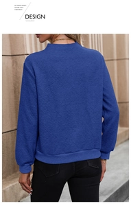 Detail of navy blue knit sweatshirt showing the unique geometric diamond textured fabric