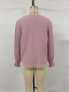 Detailed back view of pink blouse with pleated lantern sleeves and elastic smocked cuffs