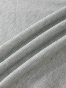 Close-up of soft heather grey knit fabric texture with natural folds on a hoodie
