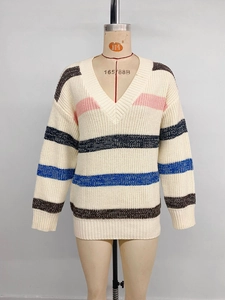 Detail of V-neck striped knit sweater showing ribbed cuffs and colorful patterns