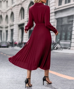 Vue détaillée d'une robe plissée rouge foncé à manches longues avec ceinture assortie
