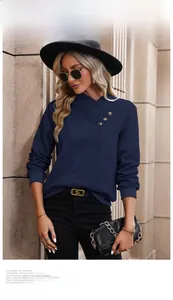 Detail of navy knit sweatshirt featuring unique cross V-neckline and shoulder button accents