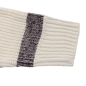 Close-up of thick knit sweater cuff featuring ribbed texture and brown stripe detail