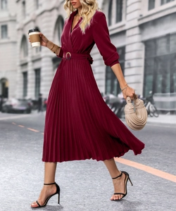 Détail d'une robe midi plissée rouge vin avec col en V et ceinture élégante à la taille