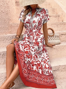 Detail of bohemian floral maxi dress with red ethnic print and tied waist on stairs