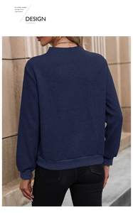 Detail of navy blue sweatshirt featuring unique diamond jacquard texture and ribbed cuffs