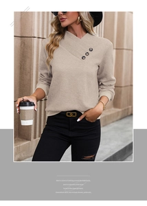 Detail view of beige long sleeve top featuring V-neckline with three decorative buttons