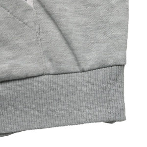 Detailed close-up of heather grey sweatshirt ribbed hem and precision side stitching