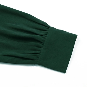 Détail des poignets plissés sur une robe en mousseline vert foncé à manches lanternes