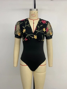 Detail of elegant V-neck bodysuit featuring floral embroidery and mesh puff sleeves