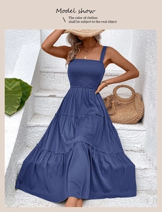 Detail showing the smocked bodice and tiered ruffled hem of the navy blue maxi dress