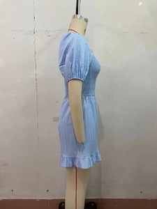 Dettaglio di una tutina azzurra con busto arricciato maniche a sbuffo e volant