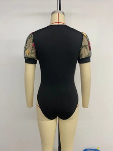 Detail view of the back of a black bodysuit featuring sheer mesh sleeves with floral embroidery