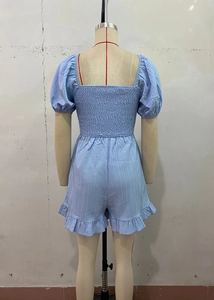 Dettaglio della tutina azzurra con schiena elasticizzata a punto smock e scollo a squadro