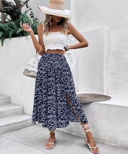 Detail of high-waisted navy floral midi skirt with side slit and pleated white tube top