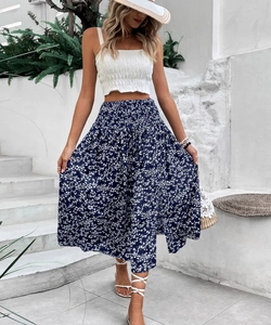 Detail of high-waisted blue floral maxi skirt with white shirred crop top for summer
