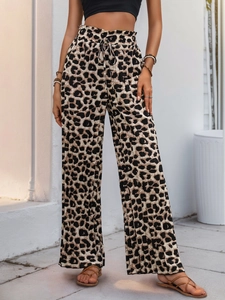 Dettaglio dei pantaloni a gamba larga con stampa leopardata e coulisse in vita