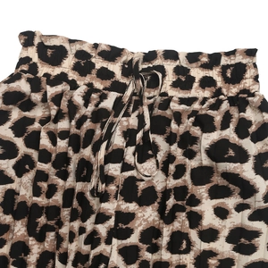Dettaglio dei pantaloni maculati a vita alta con fascia elastica e cordoncino annodato
