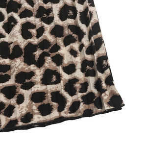 Vista macro della trama leopardata e della lavorazione a pieghe sui pantaloni larghi