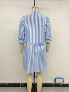 Détail d'une robe à rayures verticales bleu clair avec manches bouffantes et poignets
