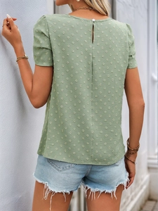 Detail of the Swiss dot fabric texture and back keyhole closure on the sage green top