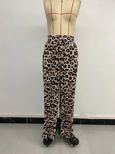 Dettaglio dei pantaloni plissettati a gamba larga maculati con vita elastica e coulisse