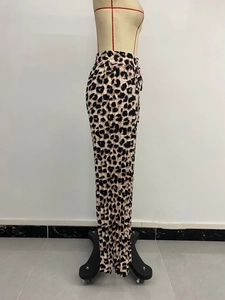 Dettaglio dei pantaloni a gamba larga leopardati con trama plissettata e lacci laterali