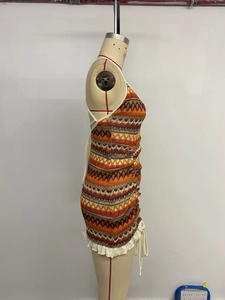 Detail of bohemian knit halter dress with colorful geometric patterns and side ruffles
