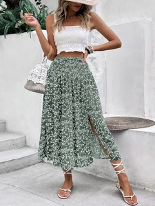Detail of high-waisted floral skirt with side slit and white pleated crop top