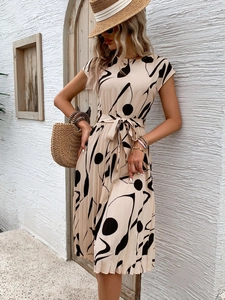 Détails de la robe plissée élégante avec imprimés abstraits noirs et lien à la taille