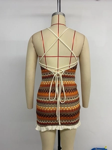 Back view of bohemian zigzag knit dress featuring lace-up details and ruffle hem