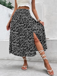 Detail of high waisted floral midi skirt featuring a side slit and elegant pleats