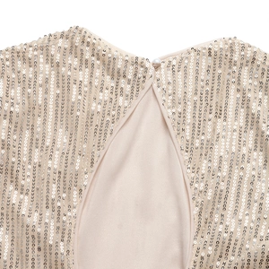 Detail of elegant sequin blouse showing back keyhole cutout and pearl button closure