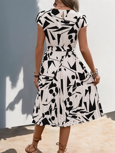 Vue arrière de la robe plissée élégante avec imprimé abstrait noir et ceinture assortie