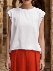 Detailed shot of white sleeveless top with decorative metal buttons on shoulders