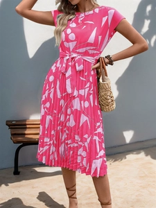 Détail d'une robe plissée sans manches rose avec imprimé géométrique et ceinture