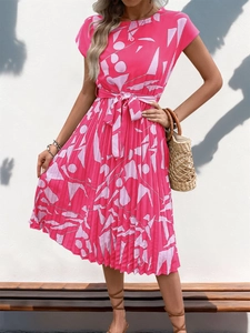 Détail d'une robe plissée magenta avec motifs abstraits et ceinture à nouer à la taille