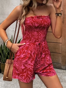 Off-shoulder strapless floral romper with red tropical leaf print and smocked waist detail