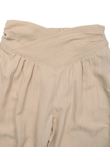 Detailed macro view of beige high waist wide leg pants showing V-cut front and elastic back